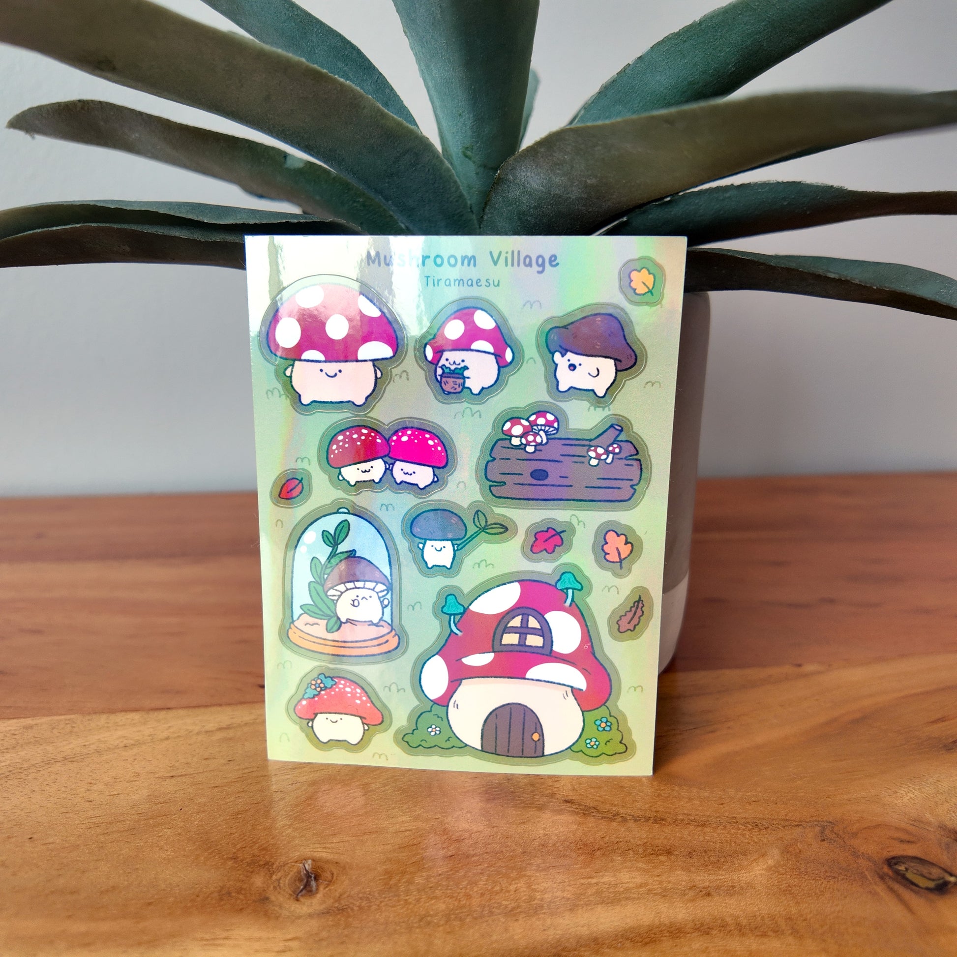 Sticker sheet with mushroom characters on a wooden surface with a plant in the background
